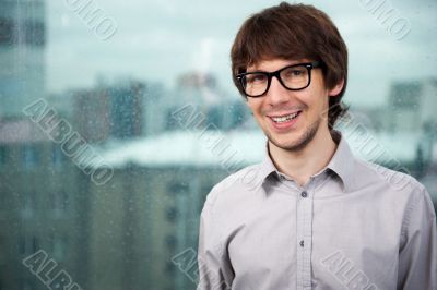 Closeup of a young smiling business man standing against big win