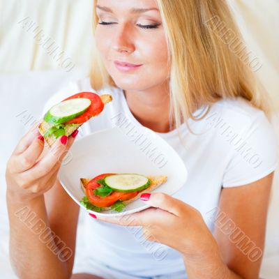 Woman having breakfast in bed. Healthy continental breakfast. Ca