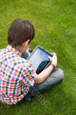 Young boy outdoors on the grass at backyard