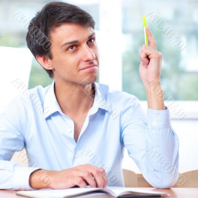 Businessman sitting indoors and writing plan in his diary Businessman sitting indoors and writing plan in his diary