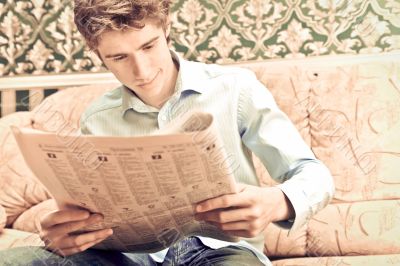 Closeup portrait of young man with newspaper 