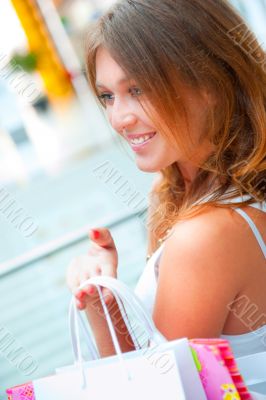 Happy shopping woman at the mall preparing gifts for her friends