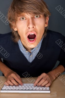 Portrait of young handsome shocked good looking man working usin Portrait of young handsome shocked good looking man working usin