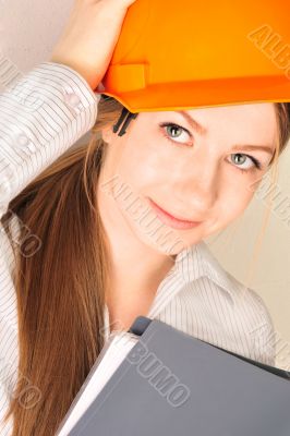 Closeup portrait of young pretty engineer woman wearing helmet