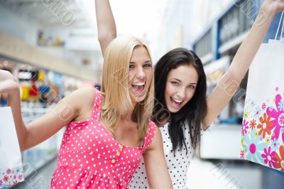 Closeup of two attractive happy girls out shopping