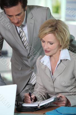 Business couple putting date in the diary Business couple putting date in the diary