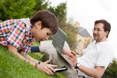 Man and young boy his son sitting outdoors 