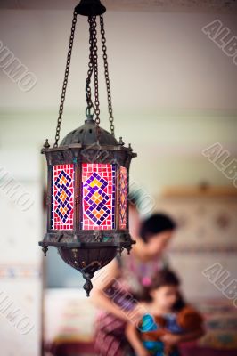 Artistic lifestyle photo of happy family: aged metal lantern on 