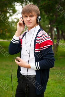 Student listening language course in headphones outside school