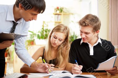 Teacher helping students in school classroom. Horizontally frame Teacher helping students in school classroom. Horizontally frame