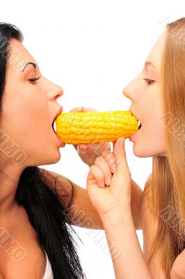 Two women eating corn at the same time from different sides