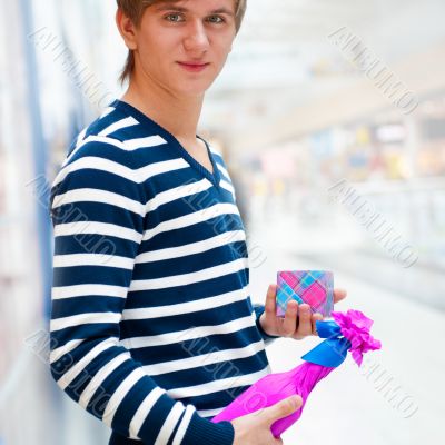 Portrait of young man inside shopping mall standing relaxed and 