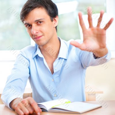 Businessman sitting indoors and writing plan in his diary Businessman sitting indoors and writing plan in his diary