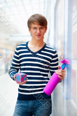 Portrait of young man inside shopping mall standing relaxed and 