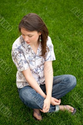 Full length of pretty young woman resting on grass and smiling