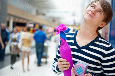 Portrait of young man inside shopping mall standing relaxed and 