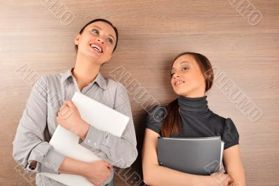 Portrait of two young handsome women standing relaxed against mo