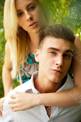 Portrait of love couple embracing outdoor in park looking happy