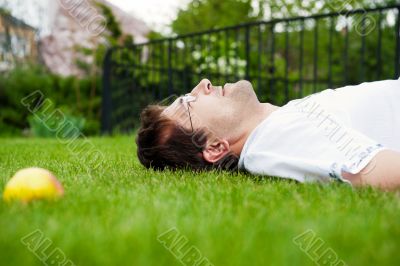 Close-up portrait of young good looking man in white shirt lying