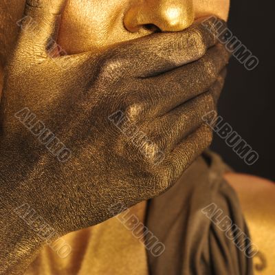 Portrait of young sexy woman in golden paint 