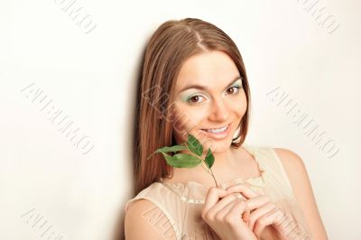 Portrait of young pretty woman holding green leave
