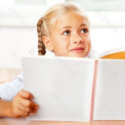 Image of smart child reading interesting book in classroom. Hori