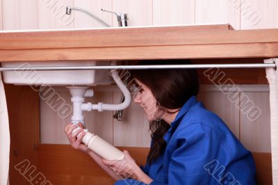 Young female apprentice plumbing a sink