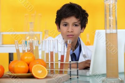 little boy analyzing oranges in the laboratory little boy analyzing oranges in the laboratory