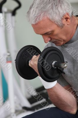 man lifting weight in sports room man lifting weight in sports room