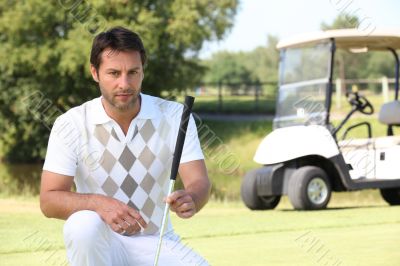 Golfer looking at the lie of his ball
