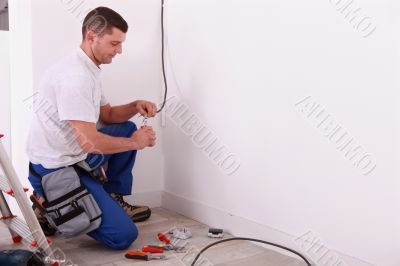 Male electrician preparing length of wire