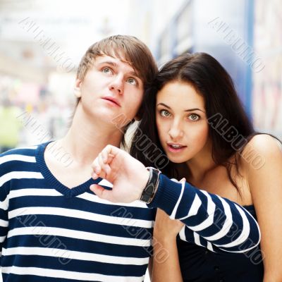 Portrait of young couple standing together at airport hall and l