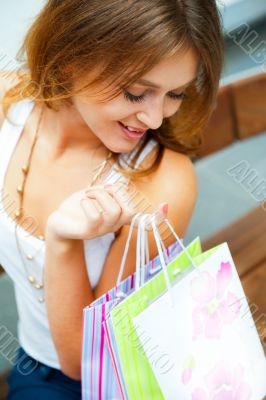 Happy shopping woman with bags and smiling. She is shopping insi