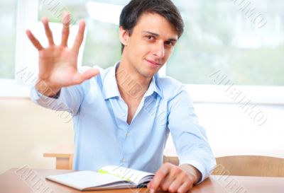 Businessman sitting indoors and writing plan in his diary