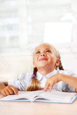 Portrait of a young girl in school at the desk.