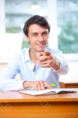 Businessman sitting indoors and writing plan in his diary