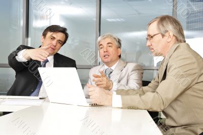 Portrait of three businessmen at the computer.