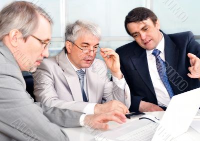 Portrait of three businessmen at the computer.