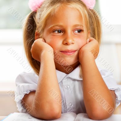 Image of smart child reading interesting book in classroom