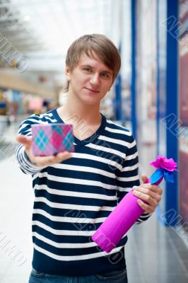 Portrait of young man inside shopping mall standing relaxed and 