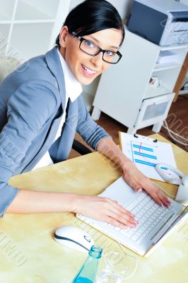 Beautiful business woman smiling while working with reports and 