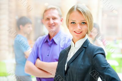  Portrait of a cute business woman with colleagues at the backgr