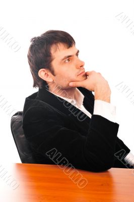 Portrait of a happy young businessman in suit sitting at office 