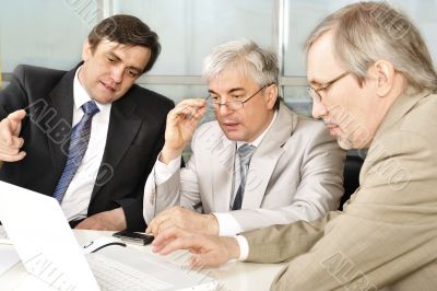 Portrait of three businessmen at the computer.