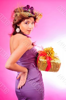 Cute smiling girl holding the golden box with red tape present o