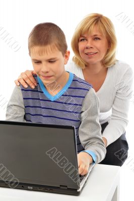 Portrait of adult woman watching as her son doing homework