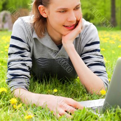 A smiling man with laptop outdoor