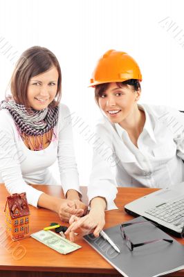 Portrait of two young women discussing construction project. Portrait of two young women discussing construction project.