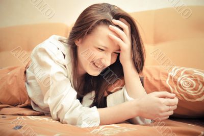 Closeup portrait of young pretty girl laying on her bed