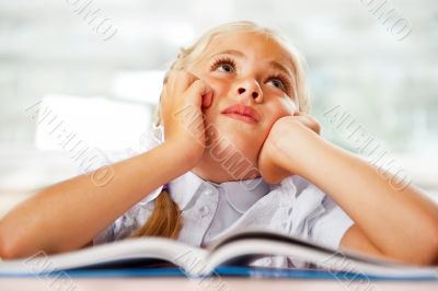 Portrait of a young girl in school at the desk.